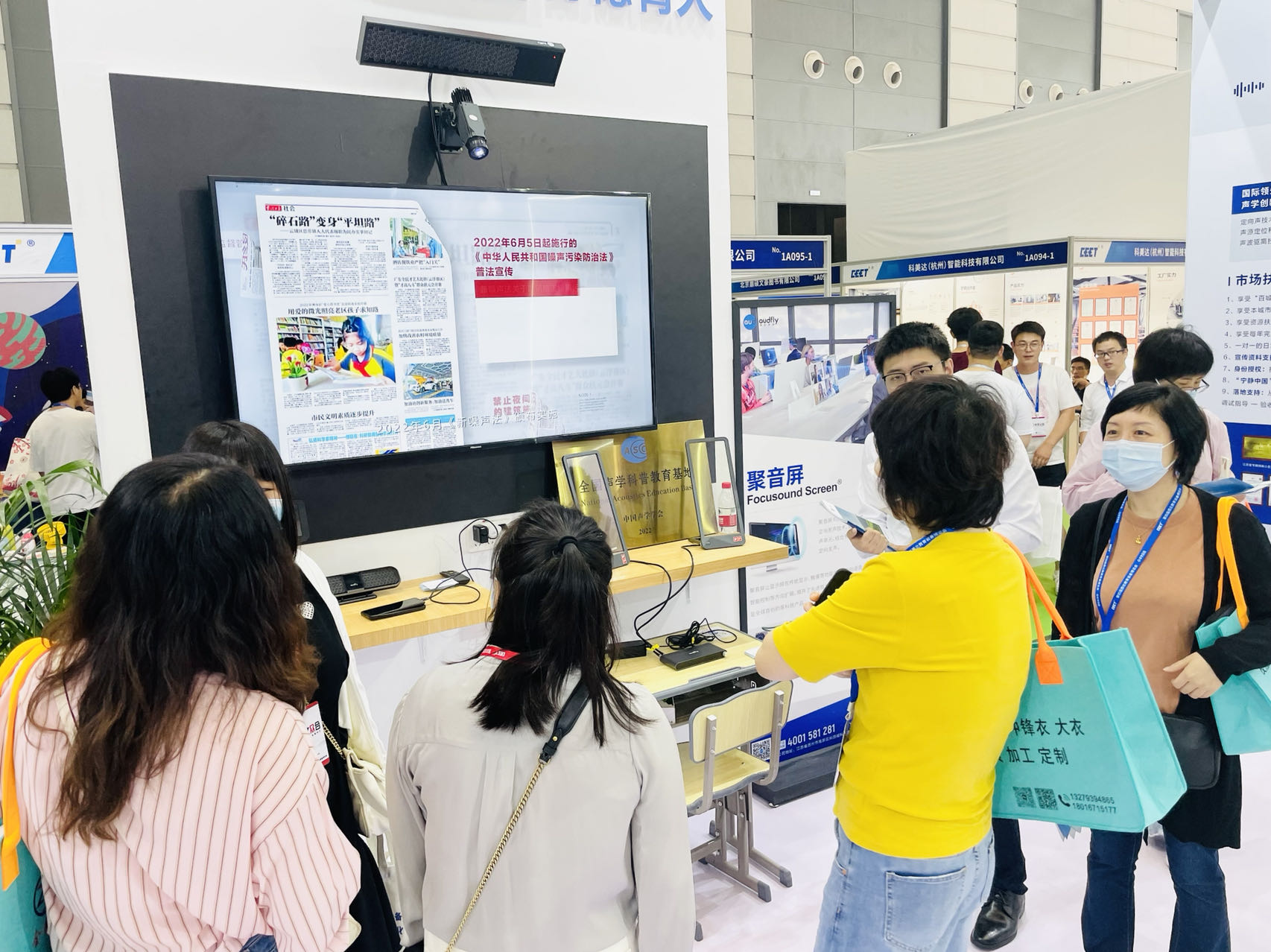 工作人員讓參展者沉浸式體驗屏幕定向音響聚音屏這款黑科技產(chǎn)品